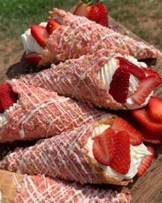 strawberry crunch cheesecake cones are on a wooden board with strawberries in the middle