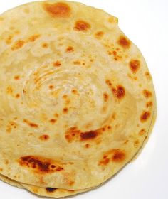 an uncooked flat bread on a white surface