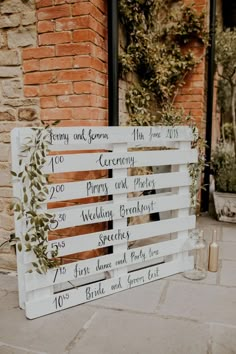 a wooden sign that has been decorated with greenery and wedding date signs on it