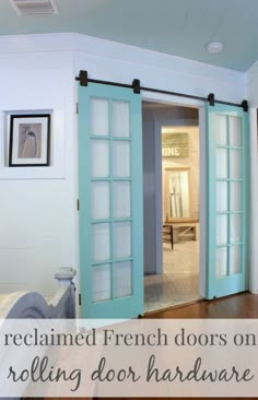 an open door leading into a bedroom with hardwood floors and white walls, along with two pictures on the wall