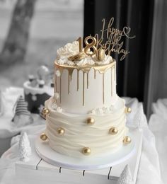 a white and gold wedding cake on top of a table