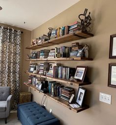 a living room filled with furniture and bookshelves next to a window covered in curtains