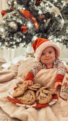 a baby sitting on a bed with cookies