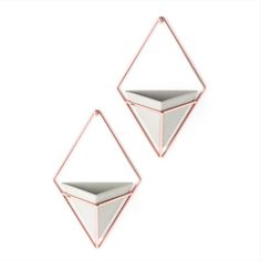 two white and rose gold earrings with geometric shapes on them, one in the shape of a pyramid