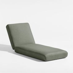 a green chaise lounge chair sitting on top of a white floor