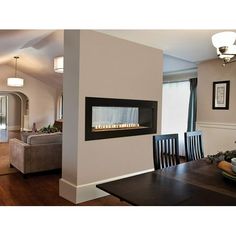 a dining room table with chairs and a fire place in the middle of it,