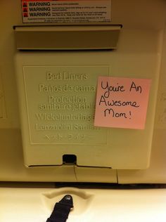 a close up of a toilet with a note attached to it