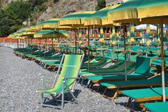 many green and yellow beach chairs with umbrellas