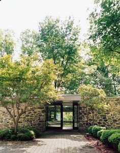 an entrance to a stone building surrounded by trees