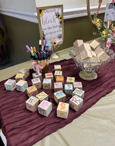 a table topped with lots of wooden blocks next to a vase filled with markers and pencils