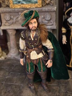 a figurine of a man dressed in green and brown clothing with long hair