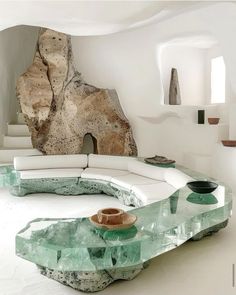 a living room filled with white furniture and large rocks