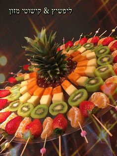 a platter filled with fruit and skewered strawberries