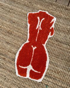 a red and white teddy bear on a brown rug