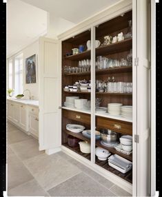 an open cabinet filled with lots of dishes