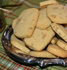 a pile of cookies sitting on top of a metal plate next to a glass jar