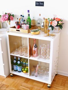 a white shelf filled with lots of bottles and glasses