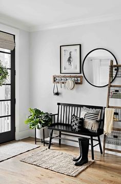 a black and white living room with wood flooring, potted plants and pictures on the wall