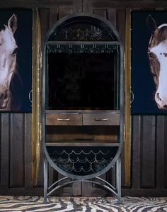 a mirror sitting on top of a wooden floor next to two pictures with horses in them