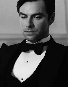 a man in a tuxedo looking at the camera