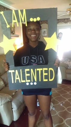 a woman holding up a sign that says i am usa talented with stars on it