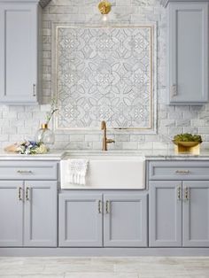 an open magazine showing a kitchen with gray cabinets and white tile backsplashes