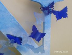 some blue butterflies are on the corner of a wall