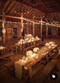 a long table with candles on it in a barn