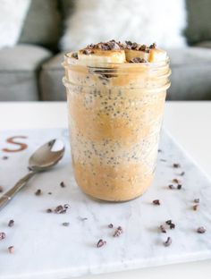 a glass jar filled with oatmeal sitting on top of a white table