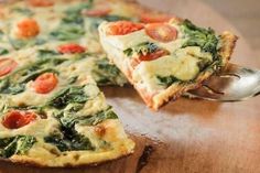 a close up of a pizza on a wooden table with a slice missing from it