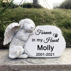 a memorial stone with an angel sitting next to it and the words forever in my heart