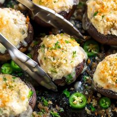 mushrooms covered in cheese and green peppers being cut by tongs on top of them