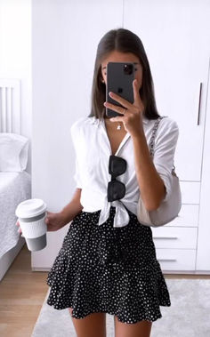 a woman taking a selfie with her cell phone and coffee cup in front of her