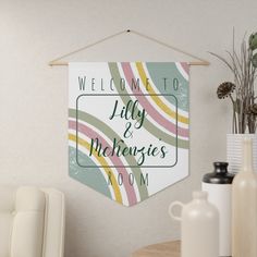 a welcome sign hangs on the wall next to a table with vases and bottles