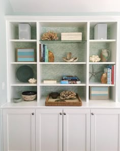 a white bookcase filled with lots of books and other items on top of it