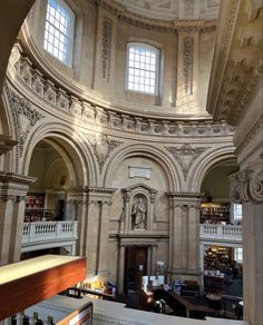 the inside of a library with many books on shelves and two large windows above it