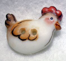 a white bird with a red hat on it's head sitting in the snow