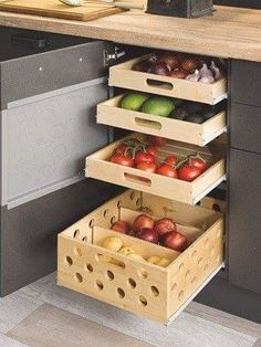 an open drawer in the middle of a kitchen with fruits and vegetables stacked inside it