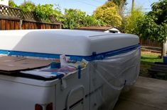 an rv covered in plastic sitting on top of a driveway