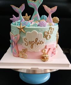 a birthday cake decorated with mermaid themed decorations