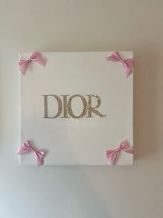 a white canvas with pink bows and the word dior on it