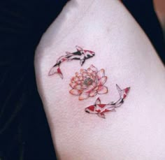 a woman's arm with two koi fish and flowers on the left side