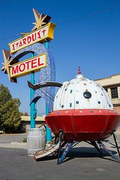 a large white and red boat sitting on top of a parking lot next to a motel sign