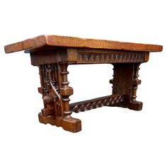 an old wooden table with intricate carvings on the top and bottom, against a white background