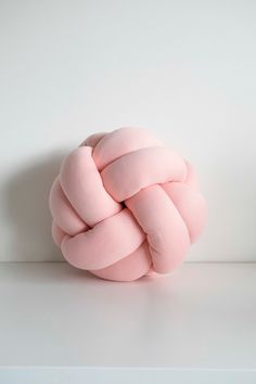 a pink knot is sitting on top of a white table and it looks like something out of