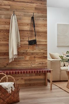 a living room with wood paneling and a bench in the corner next to a coffee table