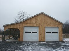 two garages in the middle of a field with snow on the ground and trees behind them