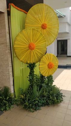 three yellow umbrellas sitting on top of a green pole in front of a building