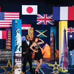 a man and woman standing in front of an american flag backdrop with flags behind them