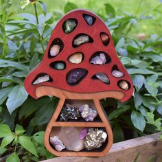 a red mushroom shaped shelf with rocks in it